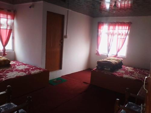 a room with two beds and two windows at Vamoose Tamang in Darjeeling