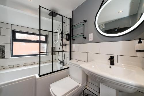 a white bathroom with a sink and a mirror at RiizeRooms at Bar TwentyTwo - central boutique hotel & bar in Worcester