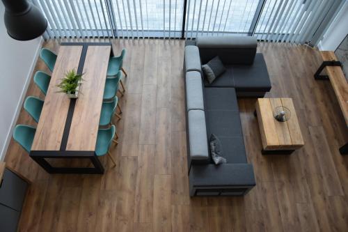 a living room with a couch and a table and chairs at Szklane Domy Roztocze 2 in Bondyrz
