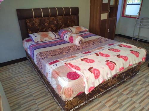 two twin beds in a room with flowers on them at Adihan Homestay Mitra RedDoorz in Palangkaraya