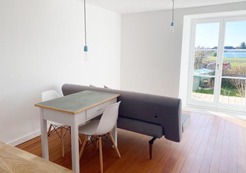 a desk and a table and chairs in a room with a window at Haus Münsterblick in Reichenau