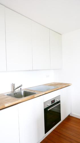 a white kitchen with a sink and a stove at Haus Münsterblick in Reichenau