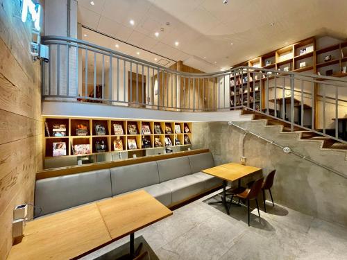 a restaurant with a bench and a table and stairs at Hotel Relief Kokura Annex in Kitakyushu