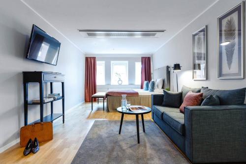 a living room filled with furniture and a tv at Biz Apartment Gärdet in Stockholm