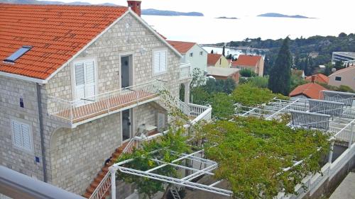 Vista árida de una casa con techo naranja en Apartments and Room Katja, en Mlini