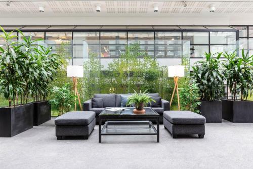 a lobby with a couch and two chairs and a table at Biz Apartment Gärdet in Stockholm