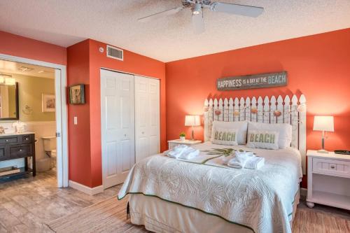 a bedroom with orange walls and a large bed at Driftwood Escape in Butler Beach