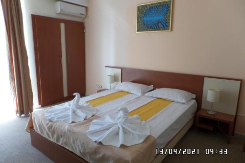 a bedroom with a bed with two white towels on it at Hotel Metropol in Mamaia