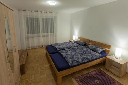 um quarto com uma cama com um edredão azul e uma janela em Casa Frida em Tettnang