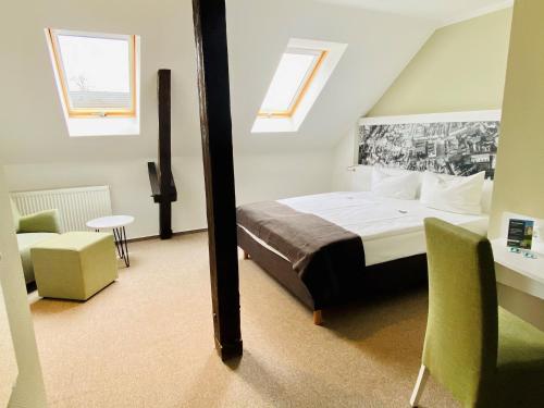 a bedroom with a bed and a table and chairs at Hotel am Schlosspark in Güstrow
