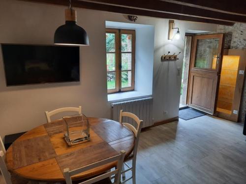 a dining room with a wooden table and chairs at Gîte du Petit Moulin in Réaumur