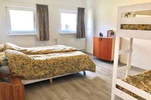 een slaapkamer met 2 bedden en een stapelbed bij Vakantiebungalow in bosrijke omgeving Luttenberg in Luttenberg