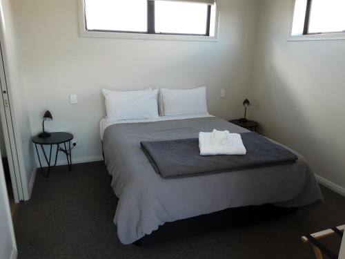 um quarto com uma cama com uma toalha branca em Two Thumbs Unit 1 em Lake Tekapo