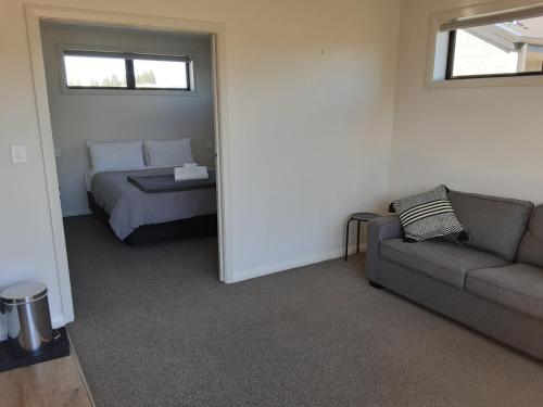 a living room with a couch and a bed at Two Thumbs Unit 1 in Lake Tekapo