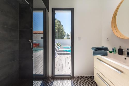 a bathroom with a glass door leading to a patio at Villa Paloma in Saint-Palais-sur-Mer
