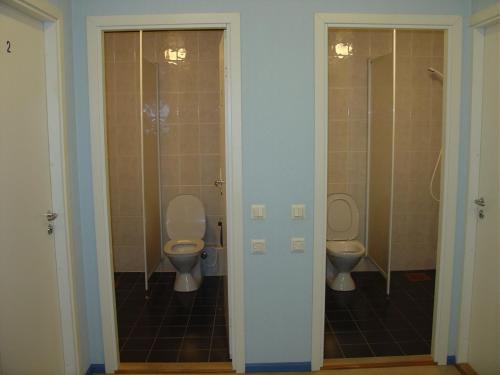 a bathroom with two toilets and two stalls at Kuressaare Airport Guest House in Kuressaare