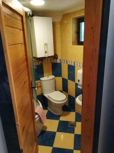 a bathroom with a toilet and a checkered floor at Etno Guest House Gorski car in Arandjelovac