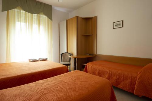 a hotel room with two beds and a window at Hotel Picador in Rimini