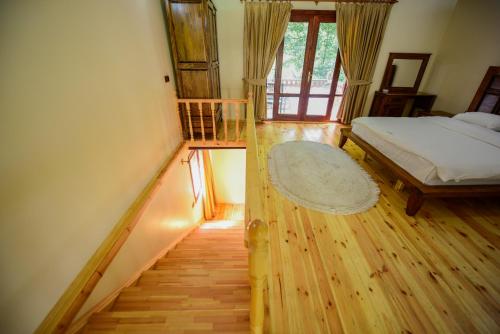 a bedroom with a bed and wooden floors and a staircase at Naturkoy Sapanca in Sakarya