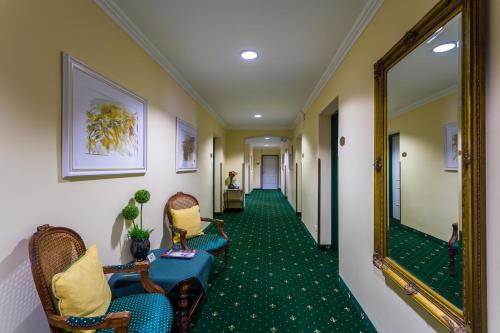 a hallway with chairs and a mirror in a hotel at Hotel Gösser Bräu in Wels