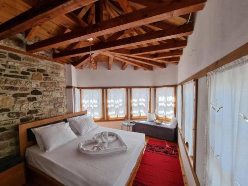 a bedroom with a bed in a room with windows at The Heart of the Bazaar Guest house in Gjirokastër