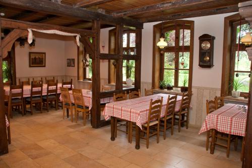 a dining room with tables and chairs and windows at Bettmann regional Einkaufen & Bauernhofurlaub in Ennigerloh