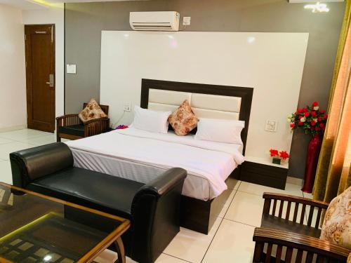 a bedroom with a large bed and a chair at Mithilesh Hotel in Kaithal