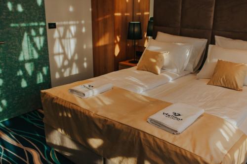 a bedroom with a bed with two towels on it at Hotel Vertigos in Tuzla