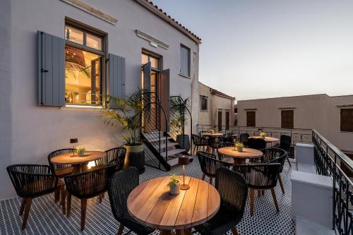 a patio with tables and chairs on a balcony at Malmo Historic Hotel in Chania Town