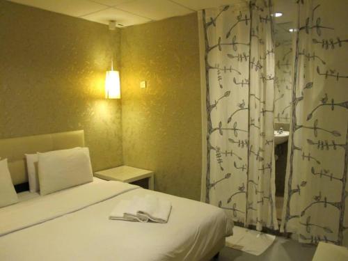 a bedroom with a bed and a curtain with writing on it at 7 Star Hotel in Kota Damansara