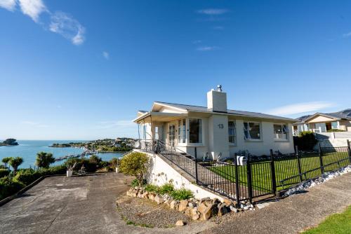 a house with a fence in front of the ocean at Riverton Views in Riverton