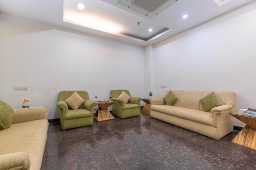 a waiting room with couches and chairs and a table at Rosewood Apartment Hotel, Gurgaon in Gurgaon