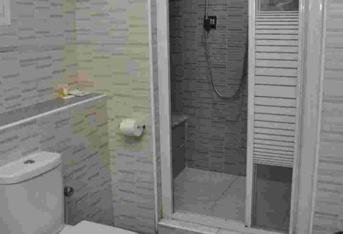 ein weißes Bad mit einer Dusche und einem WC in der Unterkunft Room in Lodge - De Brass Suites Hotel in Yenagoa