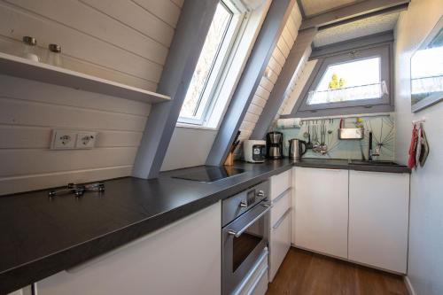 eine Küche mit weißen Schränken und einer schwarzen Arbeitsplatte in der Unterkunft Ferienwohnpark Immenstaad am Bodensee Nurdachhaus Typ 7 ND 40 in Immenstaad am Bodensee