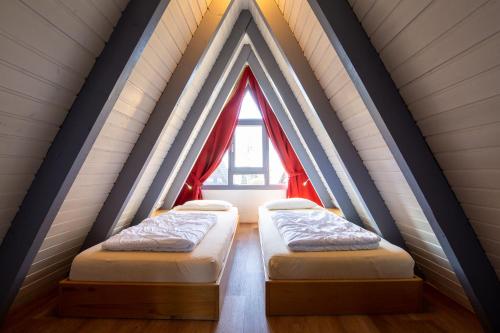 zwei Betten in einem Zimmer mit Fenster in der Unterkunft Ferienwohnpark Immenstaad am Bodensee Nurdachhaus Typ 7 ND 40 in Immenstaad am Bodensee