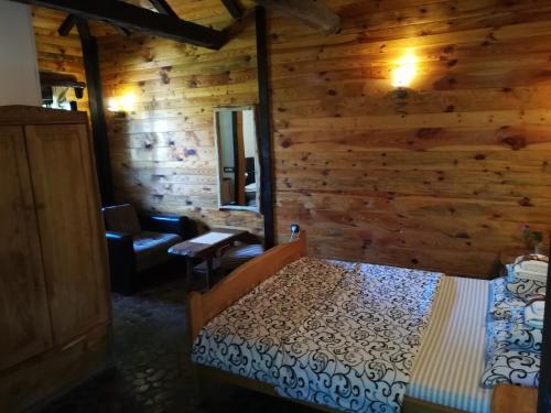 a bedroom with a bed in a log cabin at Etno Guest House Gorski car in Arandjelovac