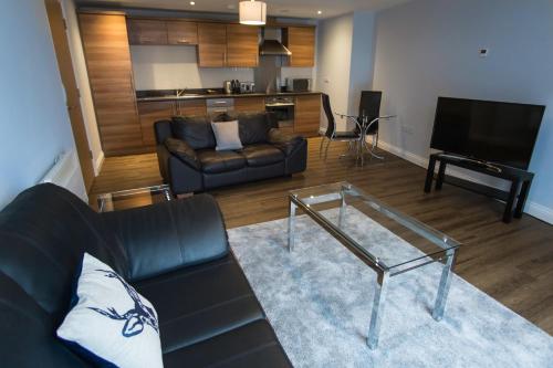 a living room with a couch and a glass table at Belgrade Plaza Serviced Apartments in Coventry