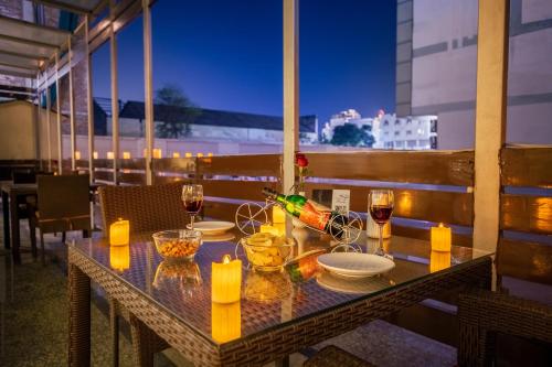 a table with glasses of wine on a balcony at Rosewood Apartment Hotel, Gurgaon in Gurgaon