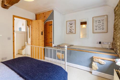 a bedroom with a bed and a staircase in a room at The Shoe Box cottage with allocated parking in Malmesbury