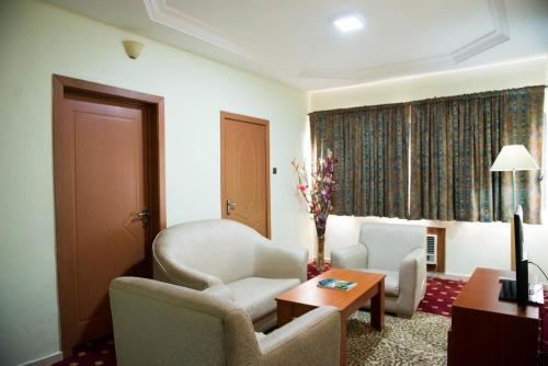 a living room with two chairs and a table at Grand Ibro Hotel - Standard in Jabi
