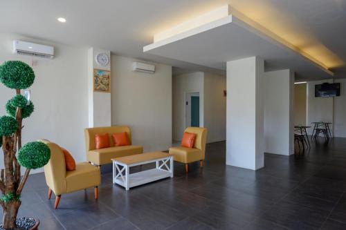 a lobby with chairs and a table in a building at RedDoorz Plus near Solo Baru in Solo