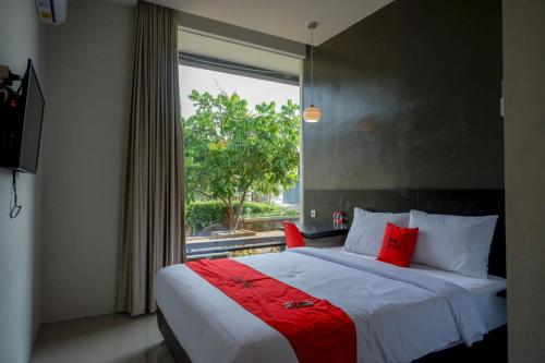 Un dormitorio con una cama grande y una ventana en RedDoorz Plus near Solo Baru, en Solo