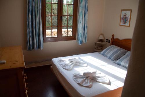 sypialnia z łóżkiem z dwoma ręcznikami w obiekcie Homenfun Menorca Playa de Fornells I w mieście Fornells
