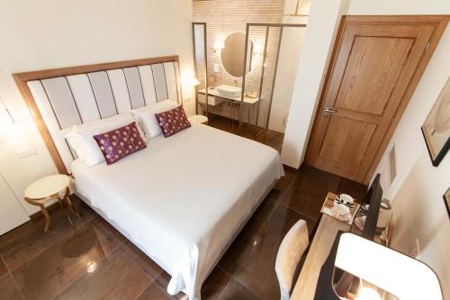 a bedroom with a large white bed with a wooden headboard at Villa Francesca Relais in Gradara
