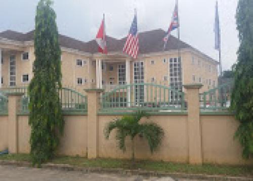 a building with two american flags in front of it at Habitat Hotel and Suites -Standard in Port Harcourt