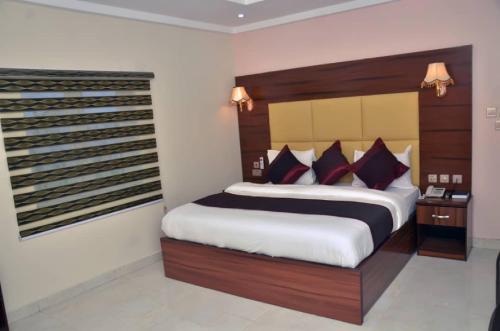 ein Schlafzimmer mit einem großen Bett in einem Zimmer in der Unterkunft Room in Lodge - Welcome to Habitat Hotel in Port Harcourt