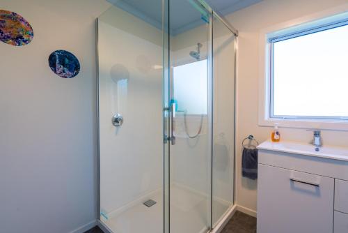 a glass shower in a bathroom with a sink at Riverton Views in Riverton