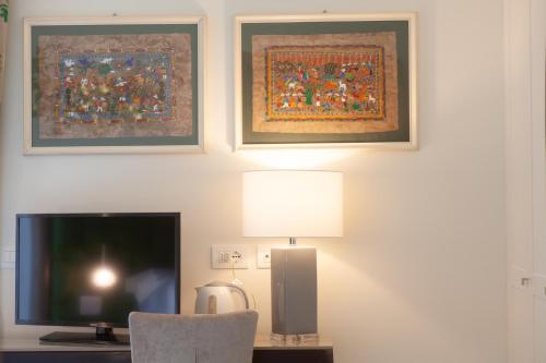 a room with a desk with a television and two pictures at Villa Francesca Relais in Gradara