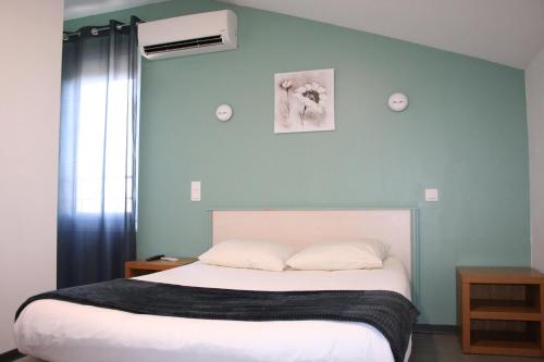 A bed or beds in a room at Hotel de la Gare