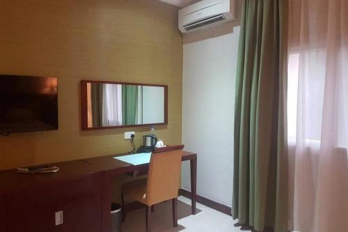 a room with a desk with a mirror and a window at Joy House Hotel - Solace in Abuja